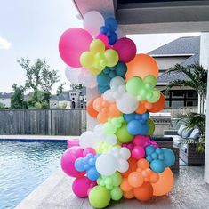 a bunch of balloons that are by a pool