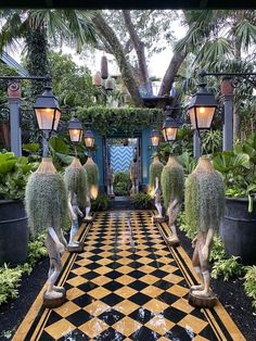 an elaborately decorated garden with potted plants and hanging lights in the center, surrounded by black and white checkered tiles