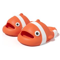 an orange and white clown fish slippers with eyes on it's sides, sitting in front of a white background