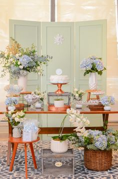 a table topped with lots of cakes and flowers