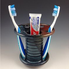 two toothbrushes sitting in a holder on a table