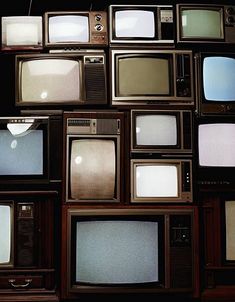 many televisions are stacked on top of each other in different colors and sizes,