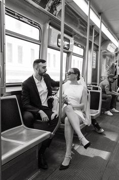 a man and woman sitting on a subway car