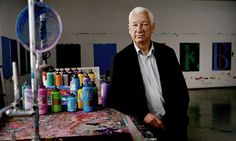 an older man standing in front of a table with lots of spray paint on it