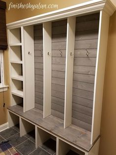 a room with some white cupboards and gray tile flooring on the wall next to a window