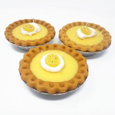 three pies with lemon slices and whipped cream on them