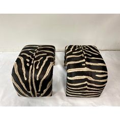 two zebra print stools sitting on top of a white sheet