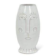 a white vase with a face drawn on it