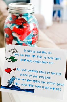 a jar filled with jelly beans sitting on top of a table next to a note