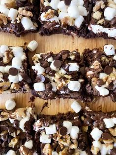 chocolate marshmallow brownies cut into squares on a cutting board with white and chocolate toppings