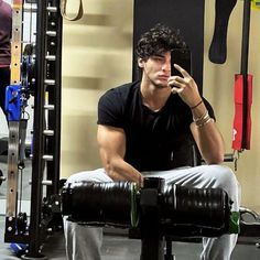 a man sitting on top of a bench in a gym