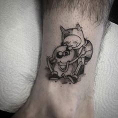 a tattoo on the foot of a person with a cat and dog in front of it