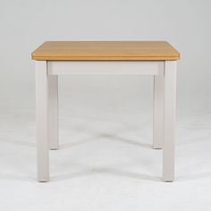 a wooden table with white legs on a plain surface