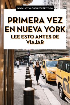 a woman is walking down the street in front of taxi cabs and a sign that reads prima vez en nueva york lee est antes de viar