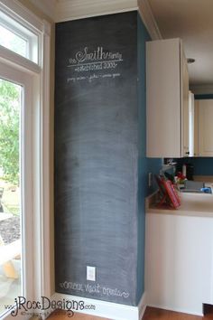 a chalkboard wall in the corner of a kitchen