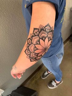 a woman's arm with a tattoo on it that has a flower in the middle