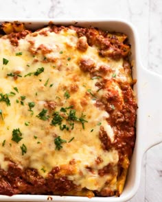 a casserole dish with meat, cheese and parmesan sauce on top