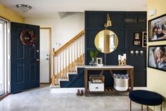 an entryway with blue walls and pictures on the wall next to it, along with a console table