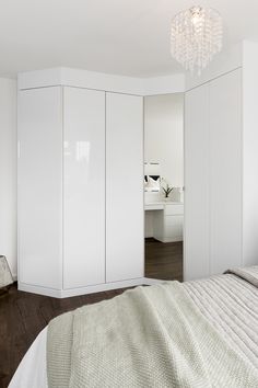 a bedroom with white closets and a chandelier hanging from it's ceiling