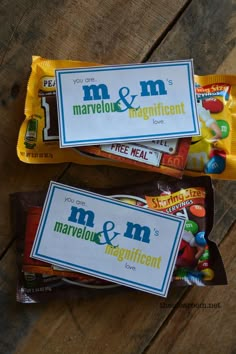 three bags of m & m candy on top of a wooden table