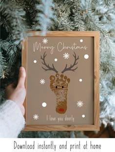 someone holding up a christmas card in front of a tree with snowflakes on it