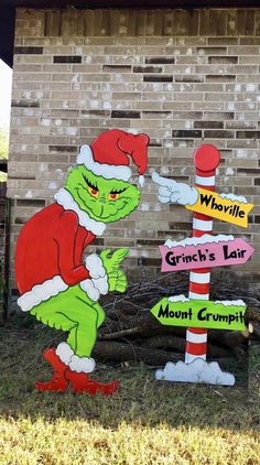 the grinch's fair sign has been decorated with santa hats and is pointing to it