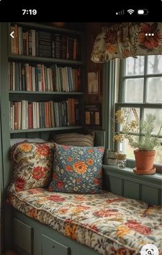 a window seat in front of a bookshelf filled with books