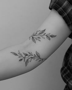 a woman's arm with leaves on it