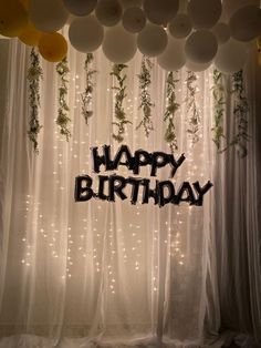 balloons and streamers are hanging from the ceiling in front of a happy birthday sign