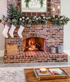 a fireplace decorated with greenery and stockings