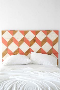 an upholstered headboard made out of wood with white and orange squares on it