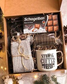 an open box with coffee, tea and socks in it next to some christmas decorations