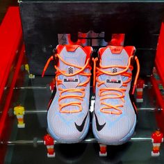 two nike shoes are on display in a shoe box with red and orange laces