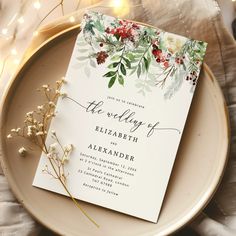 the wedding stationery is displayed on a plate with flowers and lights in the background