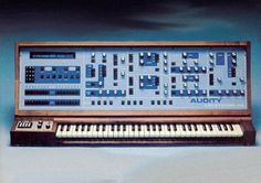 an old electronic keyboard with many buttons and knobs on the front, sitting against a blue background