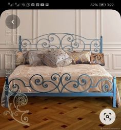 a blue metal bed sitting on top of a hard wood floor next to a white wall