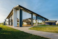 an empty building sits in the middle of a grassy area with trees and grass around it