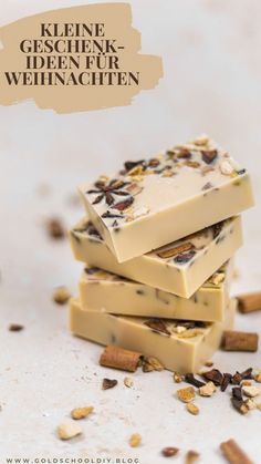 three pieces of soap stacked on top of each other with nuts and seeds around them