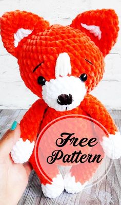 a hand holding a red teddy bear with the words free pattern in front of it