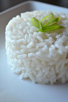 white rice is served on a plate with green garnish