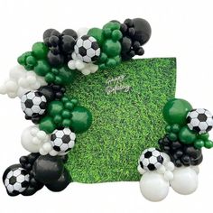 a soccer themed balloon arch with black, white and green balloons