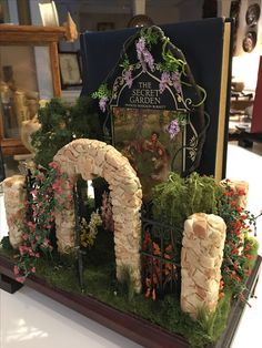 a fake garden with flowers and plants on display in a store front window or entrance