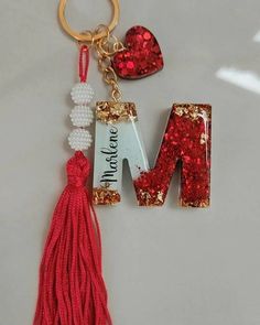 a keychain with the letter m on it and a tassel attached to it