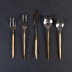 four forks, two spoons and one knife on a table