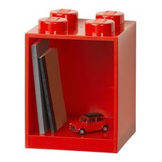 a red lego bookcase with a toy car in it