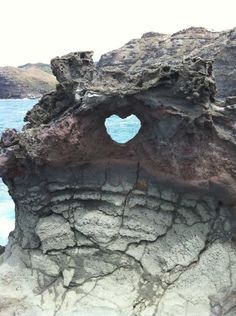 a heart shaped hole in the rocks by the ocean