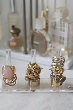 three different types of rings sitting on top of a white counter next to a mirror