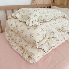 two blankets are stacked on top of each other in a crib with pink sheets