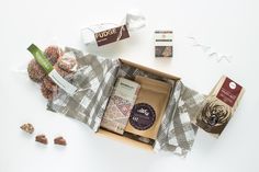 an open box filled with assorted candies and chocolates on top of a checkered table cloth