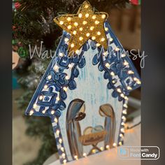 a christmas ornament with lights on it and a nativity scene in the background